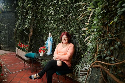 La Virgen de la Medalla Milagrosa, entre dos sillas, da la bienvenida a un pasillo cubierto por la enredadera