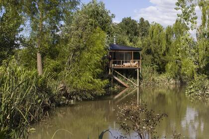 La vista desde el agua muestra la casa integrada al paisaje con su revestimiento de chapa verde acanalada y la cubierta negra del mismo material.