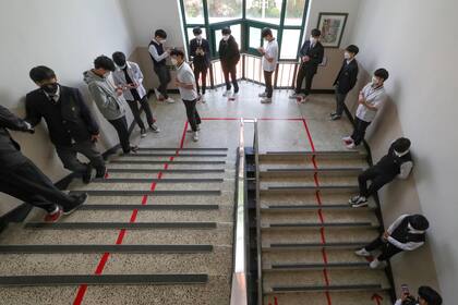 Los alumnos hacen cola en una escalera para poder entrar a las aulas