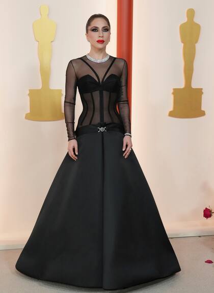 Lady Gaga lució un vestido de Versace en color negro con transparencias, el cual complementó con joyas en color plata