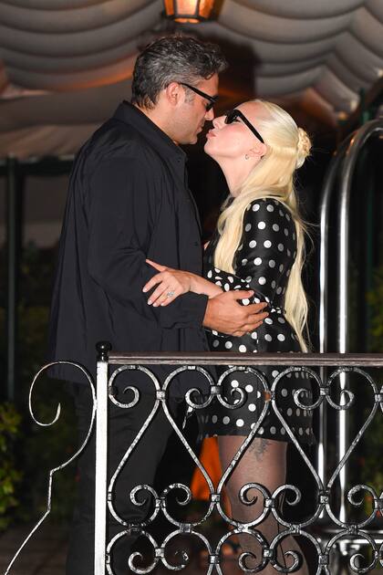 Lady Gaga y Michael Polansky no pudieron evitar mostrarse muy cariñosos. Incluso, le regalaron un beso de película a los periodistas que la aguardaban en el aeropuerto. Luego, se acurrucaron en un taxi acuático mientras Gaga alardeaba de su enorme anillo de diamantes. En cuanto a su look, la artista lució un vestido corto negro de falda acampanada inspirado en los años 60 con un estampado de lunares blancos