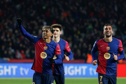 Lamine Yamal, izquierda, del Barcelona, celebra frente a sus compañeros de equipo después de marcar el quinto gol de su equipo durante el partido de fútbol de la Copa del Rey entre Barcelona y Real Betis en el estadio olímpico Lluis Companys en Barcelona, España, el miércoles 15 de enero de 2025. (AP Foto/Joan Monfort)