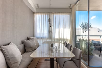 Lámpara colgante (Griscan). Mesa con tapa de Neolith ‘Calacatta’ de casi dos metros acompañada por un banco amurado.