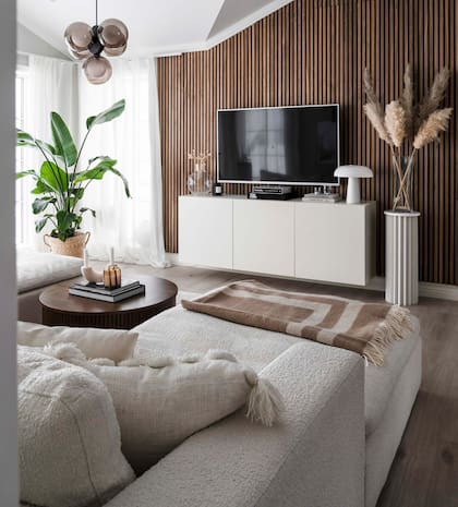 Lámpara colgante (Ljustema). Aunque se trate de un espacio secundario, no faltan plantas ni se renunció a incorporar objetos decorativos, de modo tal de conseguir que la sala de TV resulte tan acogedora como el living.