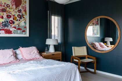 Lámpara globo (Mercado de Pulgas, La Merello) y somier (Springwall) con acolchado de lino (West Elm) y almohadones y manta rosa (Casa Almacén). Espejo redondo (La Charrúa). Mesa de luz (Talleres Sustentables). Velador (La Feliz). Cuadro de Josefina Barba. Alfombra artesanal (Graciela Churba).