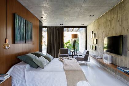 Lámparas colgantes (Lumishop). Díptico fotográfico de Silvina Schell. En la pared de hormigón, sujetaron un estante voladizo enchapado en lapacho.