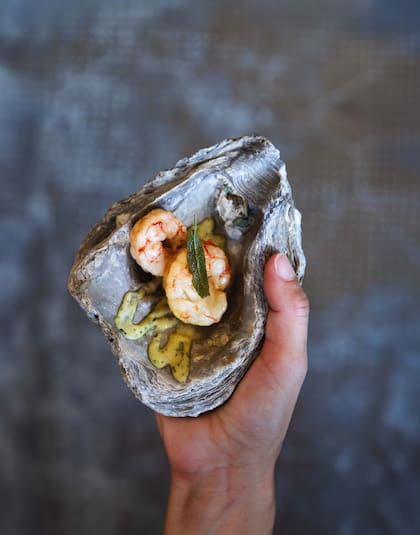 Langostinos con salsa de salicornia servidos en una ostra fosilizada.