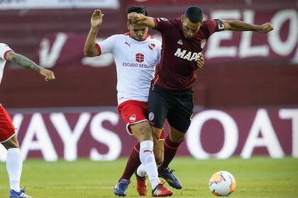 Sergio Barreto, de Independiente, trata de evitar que José Sand, de Lanús, se vaya con la pelota.