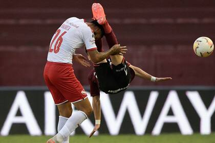 Alexander Barboza, de Independiente, se juega el físico en una pelota dividida con Franco Orozco, de Lanús.
