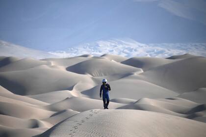 Un piloto camina sobre una duna de arena durante la Etapa 5 del Rally Dakar 2018 entre San Juan de Marcona y Arequipa en Perú