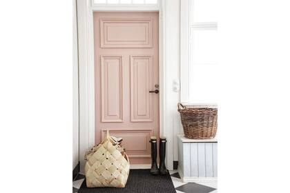Las aberturas son puntos interesantes para sumar color a la casa. En este caso, un calmo rosa viejo viste una puerta antigua con molduras