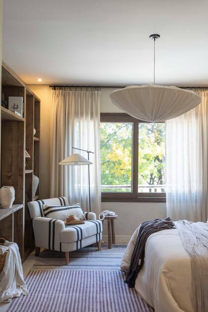 Las alfombras (Sol Palou Deco) llevan calidez, pero con distinta impronta, a la zona social y también al dormitorio. El tapizado a rayas se hace eco del de las sillas del comedor diario.