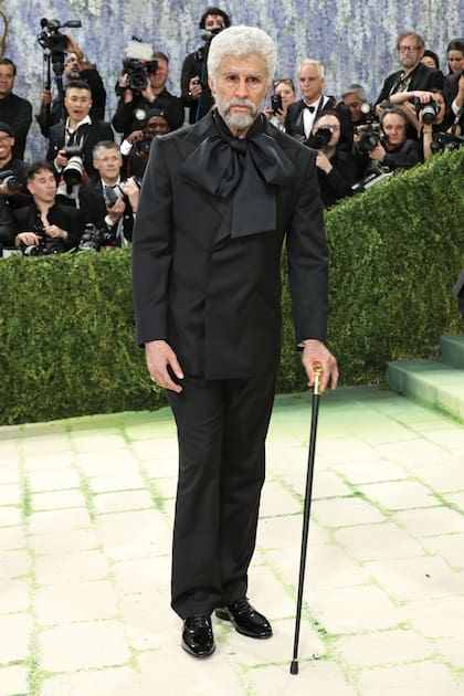 Las apariciones de Bad Bunny en la Met Gala son una declaración. Este año, quiso poner sobre el tapete la normalización de la juventud: apareció con el pelo blanco y arrugas en la cara, cuello y manos, un efecto logrado por el maquillador Mike Marino. El smoking, que codiseñó junto con Zara, hacía referencia al traje de 1947 del diseñador Charles James. Como accesorios, un reloj y un bastón