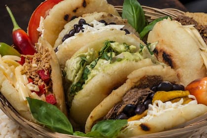 Las arepas son de harina de maíz y vienen con distintos rellenos, entre ellos porotos con queso blanco o pollo con palta.