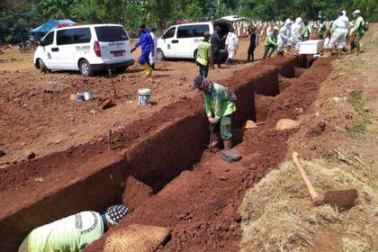 Autoridades locales ordenaron a los infractores de los protocolos de salud en Gresik, Java Oriental, a trabajar como sepultureros