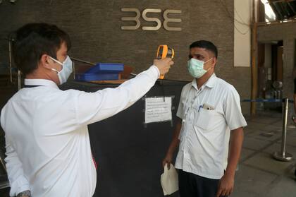 Las autoridades sanitarias toman la temperatura a las personas en India como control