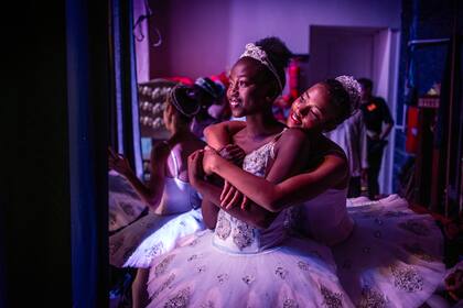 Las bailarinas Pauline Okumu y Natalia Como se abrazan en el backstage durante la producción del 'Cascanueces', un ballet clásico que se representa tradicionalmente en el período navideño, en el Teatro Nacional de Kenia, en Nairobi, el 2 de diciembre de 2023