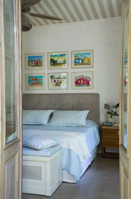 “Las camas grandes como esta, que es de 2x2m, son más difíciles de vestir. Para mí, funciona un estilo neto, con pocos elementos grandes, como estos almohadones”, recomienda. Funda de edredón de lino acqua con almohadones a cuadros (Melissa Domit). A los cuadros los trajo hace unos años de un viaje: “Son una ventana a Bahía”.