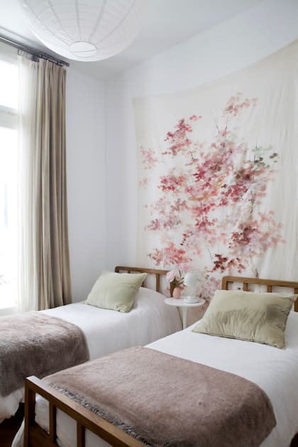 Las camas (Mesopotamia) se acompañan con mesas de luz ‘Tulip’ y ropa de cama (Casa Leopoldo). La obra de gran formato es de Catalina Ruiz.