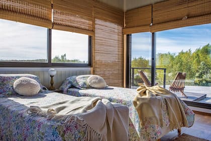 En el cuarto de huéspedes, cortinas de esterilla y sillas exteriores del Puerto de Frutos de Tigre. Almohadones tejidos (Everything), Mantas (Arredo). Pies de cama artesanales (Quiero Norte).