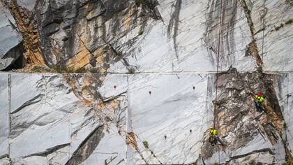 Trabajadores, conocidos como "Tecchiaiolo", examinan el mármol en la cantera de Cervaiole en Monte Altissimo en los Alpes Apuanos, Toscana