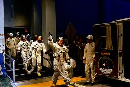 Los astronautas Neil Armstrong, Michael Collins, Buzz Aldrin se dirigen a un vehículo que los llevará a la plataforma de lanzamiento