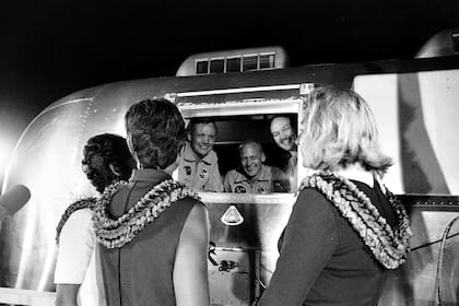 Los astronautas del Apolo 11, todavía en su cápsula de cuarentena, son recibidos por sus esposas en la Base de la Fuerza Aérea de Ellington, 27 de julio de 1969