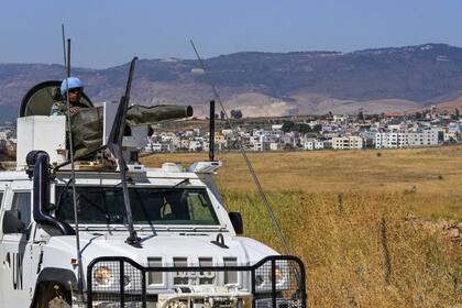 Las fuerzas de mantenimiento de la paz de la ONU patrullan en el lado libanés de la frontera libanés-israelí en la aldea sureña de Majidiyeh, con la fronteriza Ghajar al fondo, el martes 11 de julio de 2023. (AP/Hassan Ammar)