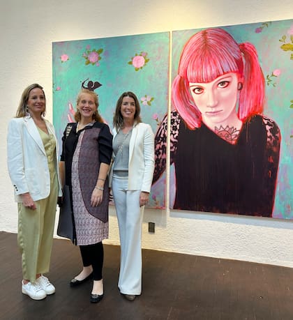 Las fundadoras de Diderot, Lucrecia Cornejo y Angie Braun, rodean a la curadora para la Argentina, Stefy Jaugus; detrás, una obra de Sergio Porro