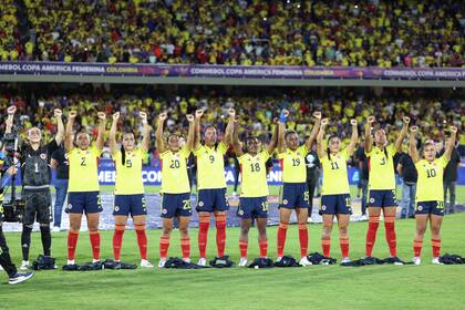 Las futbolistas del seleccionado de Colombia levantan los brazos en señal de protesta por la falta de organización de la disciplina en su país