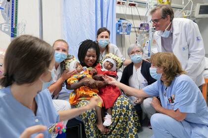 Las hermanas gemelas Ervina y Prefina con su madre y el equipo médico después de una cirugía craneal exitosa en el hospital pediátrico del Niño Jesús (Bambino Gesu) en Roma