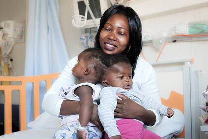 Las hermanas gemelas Ervina y Prefina con su madre antes de una cirugía craneal exitosa en el hospital pediátrico del Niño Jesús (Bambino Gesu) en Roma
