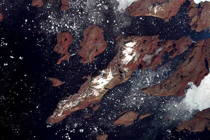 Fotografía tomada desde la nave espacial Terra de la NASA. Esta imagen muestra la costa oeste de Groenlandia, una de las principales incubadoras de la Tierra para los icebergs: grandes bloques de hielo terrestre que se desprenden de los glaciares y flotan en el océano