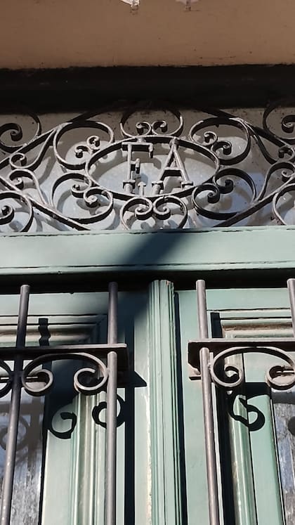 Las iniciales del dueño en la puerta original de hierro forjado.
