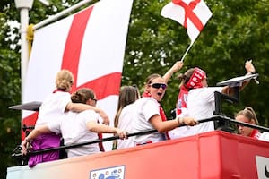 Las jugadoras de fútbol de Inglaterra celebran junto a la bandera de la Cruz de San Jorge durante el desfile de la victoria de las Leonas el 29 de julio.