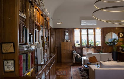 Las luminarias son claves en el interiorismo de Mónica. Para la la claraboya, diseñó una inmensa lámpara espiralada; en las paredes laterales, reutilizó unas vainas que encontró en el departamento y les colocó faroles de galpón ferroviario.