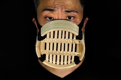 Edmond Kok, diseñador de vestuario y actor de teatro de Hong Kong, usa una mascarilla que representa un vaporizador de bambú chino