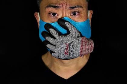 El artista usa una mascarilla diseñada con un guante de peluche pegado, que representa una mano sobre su boca, que lo hace ver asustado