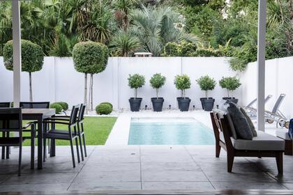 Después: las medianeras blancas resaltan las formas verdes y repiten el tono de las piedras elegidas.