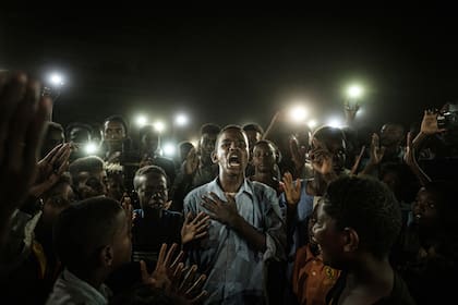 Sudán, Jartum. La foto tomada por el fotógrafo Yasuyoshi Chiba muestra a un joven recitando poemas en medio de un grupo de manifestantes, a la luz de varios teléfonos celulares. El reportero ha sido galardonado con el World Press Photo del año 2020