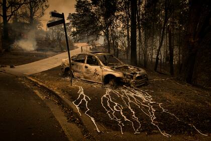 El aluminio, que se derrite a 660 grados, chorrea de un auto quemado en Conjola Park, una ciudad donde los incendios forestales arrasaron más de 89 propiedades, en Nueva Gales del Sur, Australia, el 31 de diciembre de 2019. Foto de Matthew Abbott para The New York Times