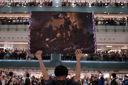 Un hombre sostiene un cartel en Shatin, Hong Kong, invitando a que la gente se una a la canción de protesta que ganó popularidad en la ciudad como himno no oficial, el 11 de septiembre de 2019. La foto de Nicolas Asfouri de AFP ganó el primer premio en la categoría Historias de información general