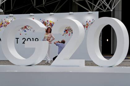 Una mujer posa para una foto detrás de una instalación de la cumbre del G20