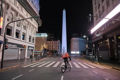 Una inusual postal nocturna de la zona del Obelisco porteño, las calles vacías y las bicicletas circulando a contra mano, por las restricciones por la pandemia del coronavirus, 6 de abril