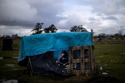 Ángel posa para una foto dentro de su casilla durante la toma de terrenos de Guernica, provincia de Buenos Aires, 27 de septiembre