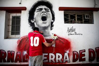 Un fanático llora frente a un mural de Diego Maradona en el estadio de Argentinos Juniors, el día de su muerte, 25 de noviembre