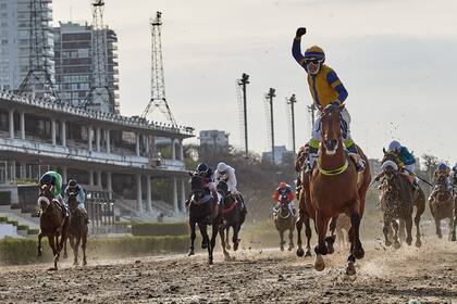 Un corredor festeja el triunfo de la polla de potrancas en el hipódromo de Palermo, 3 de octubre