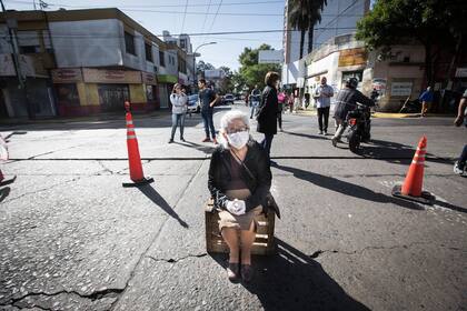 En medio de las restricciones por la pandemia del Covid-19, una mujer hace la cola para cobrar la jubilación en un banco de la localidad de Morón, 4 de abril