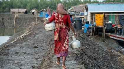 Las mujeres en Bangladesh va a buscar agua potable después de que su pueblo se viera afectado por la intrusión de agua salada