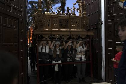 Las mujeres llamadas "los costaleros" actúan y llevan carrozas en el tradicional paso de la hermandad durante la semana previa a la Semana Santa en La Campana, un pueblo a 50 minutos de Sevilla, España 